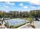Aerial view of well-maintained community tennis courts and pond with fountain at 529 Azalea Bloom Dr, Loganville, GA 30052