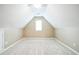 Finished attic featuring neutral paint, dormer window for natural light, and soft carpeting at 1008 Walnut Creek Dr, Woodstock, GA 30188