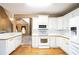 Bright kitchen with white cabinets, appliances, hardwood floors, and open layout to the living area at 1008 Walnut Creek Dr, Woodstock, GA 30188