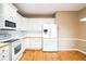 Bright kitchen featuring white cabinets, appliances, and hardwood floors for a clean and inviting space at 1008 Walnut Creek Dr, Woodstock, GA 30188