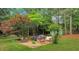 Serene backyard featuring a fire pit with outdoor seating, surrounded by lush greenery and mature trees at 1050 Chestnut Hill Sw Cir, Marietta, GA 30064