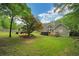 Green backyard with mature trees, deck, and hot tub, perfect for outdoor enjoyment at 1050 Chestnut Hill Sw Cir, Marietta, GA 30064