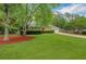 Attractive brick home with a green lawn, mature trees, and a driveway leading to an attached garage at 1050 Chestnut Hill Sw Cir, Marietta, GA 30064