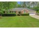 Beautiful brick home with lush green lawn, trimmed bushes, and a two-car garage at 1050 Chestnut Hill Sw Cir, Marietta, GA 30064