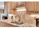 Close-up of kitchen sink, tile backsplash, and granite countertops in a well appointed kitchen at 1050 Chestnut Hill Sw Cir, Marietta, GA 30064