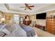 Carpeted main bedroom featuring a ceiling fan, TV, and attached bathroom with a tub at 1050 Chestnut Hill Sw Cir, Marietta, GA 30064