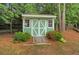 A charming green shed with white trim, nestled amongst mature trees at 1050 Chestnut Hill Sw Cir, Marietta, GA 30064