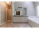 Bright bathroom with a double vanity, large mirror, separate shower, and soaking tub at 2950 Camary Place Se Dr, Conyers, GA 30094