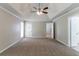 Spacious bedroom featuring neutral carpeting, tray ceiling and entry door to the patio at 2950 Camary Place Se Dr, Conyers, GA 30094