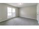 Neutral bedroom featuring a large window, plush carpet, and white door at 2950 Camary Place Se Dr, Conyers, GA 30094