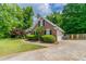 Side view of brick home with a well-kept lawn and driveway leading to an attached garage at 2950 Camary Place Se Dr, Conyers, GA 30094