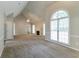 Open living room featuring a fireplace, ceiling fan, vaulted ceiling, and large arched window at 2950 Camary Place Se Dr, Conyers, GA 30094