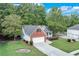 Aerial view of a charming brick and siding home with a long driveway and a spacious yard, nestled among mature trees at 3238 Sharp Creek Ln, Buford, GA 30519