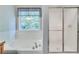 Bright bathroom featuring a soaking tub, a shower with glass doors, and a window at 3238 Sharp Creek Ln, Buford, GA 30519