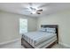 Cozy bedroom with a ceiling fan, neutral walls and carpet, and a bed with striped linens at 3238 Sharp Creek Ln, Buford, GA 30519