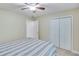 Bedroom with a ceiling fan, neutral walls and carpet, a bed with striped linens, and closet doors at 3238 Sharp Creek Ln, Buford, GA 30519