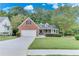 Charming single-Gathering home showcasing brick and siding with a well-manicured lawn and mature trees at 3238 Sharp Creek Ln, Buford, GA 30519