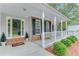 Inviting front porch featuring brick accents, white columns, fresh landscaping and a storm door at 3238 Sharp Creek Ln, Buford, GA 30519