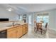Bright kitchen and dining area with stainless steel sink, view to the carpeted living room with fireplace, and outdoor access at 3238 Sharp Creek Ln, Buford, GA 30519