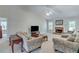 Bright living room showcasing a brick fireplace, plush carpeting, and abundant natural light at 3238 Sharp Creek Ln, Buford, GA 30519