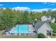 Aerial view of a community pool surrounded by trees, a covered area, and lounge chairs at 3238 Sharp Creek Ln, Buford, GA 30519
