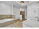 Luxurious bathroom featuring garden tub, a separate shower, double sinks, tile flooring and stone accents at 416 Wilfawn Way, Avondale Estates, GA 30002