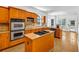Bright kitchen features wood cabinets, double ovens, island with cooktop, and stainless steel appliances at 416 Wilfawn Way, Avondale Estates, GA 30002