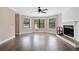 Spacious living room featuring hardwood floors, fireplace, large windows, and a ceiling fan at 893 Sandune Dr, Norcross, GA 30093
