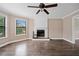 Open living room boasting hardwood floors, fireplace, big windows, and a ceiling fan at 893 Sandune Dr, Norcross, GA 30093