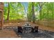 Backyard with patio seating and surrounded by a wooden fence and mature trees at 1025 Taylor Oaks Dr, Roswell, GA 30076