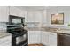 Well-lit kitchen with granite countertops, stainless sink and black appliances at 1025 Taylor Oaks Dr, Roswell, GA 30076