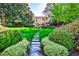 Lush backyard featuring a stepping stone pathway leading up to an elegant home at 15 Cherokee Nw Rd, Atlanta, GA 30305