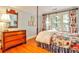 Comfortable bedroom featuring hardwood floors, a floral bedspread and a wooden dresser at 15 Cherokee Nw Rd, Atlanta, GA 30305