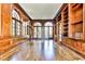 A grand wood paneled library with floor to ceiling windows, built in shelving, and gleaming hardwood floors at 15 Cherokee Nw Rd, Atlanta, GA 30305