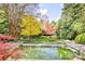Serene backyard pond with fountain features, lush landscaping, and colorful trees at 15 Cherokee Nw Rd, Atlanta, GA 30305