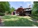 Expansive backyard with lush greenery, mature trees, and a home featuring a stone patio and wooden deck at 310 Anders Path, Marietta, GA 30064
