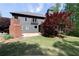 Expansive backyard view featuring a stone patio, lush lawn, mature trees, and the rear exterior of the home at 310 Anders Path, Marietta, GA 30064