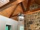 Charming living room features wooden beams and a unique spherical chandelier, complemented by a stone accent wall at 310 Anders Path, Marietta, GA 30064