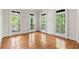 Bright room with hardwood floors and multiple windows to a balcony with wooded views at 310 Anders Path, Marietta, GA 30064