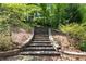 Stone staircase ascending through lush greenery, blending natural beauty with elegant landscape design at 310 Anders Path, Marietta, GA 30064