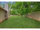 Spacious, level backyard is completely fenced in with mature trees and a lush lawn at 672 Bostonian Way, Lawrenceville, GA 30046