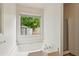 Bathroom featuring a soaking tub underneath a window and glass-enclosed shower at 672 Bostonian Way, Lawrenceville, GA 30046