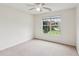Bright bedroom with plush carpeting, ceiling fan, and large window offering plenty of natural light at 672 Bostonian Way, Lawrenceville, GA 30046