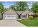 Charming single-story home with a two-car garage, well-manicured lawn, and mature trees at 672 Bostonian Way, Lawrenceville, GA 30046