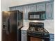 Kitchen featuring black appliances, blue-gray cabinets, and bright white countertops at 672 Bostonian Way, Lawrenceville, GA 30046