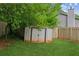 Backyard shed for extra storage, surrounded by lush greenery and a privacy fence at 672 Bostonian Way, Lawrenceville, GA 30046