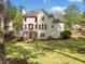Backyard view featuring a deck, fenced yard and well-manicured lawn surrounded by mature trees at 1126 Gate Post Ct, Powder Springs, GA 30127