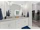 Bathroom with double sinks, quartz countertops, crystal light fixtures, and a tiled floor at 1126 Gate Post Ct, Powder Springs, GA 30127