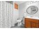 Bathroom with a white shower curtain, wood vanity, and matching wood cabinet above the toilet at 1126 Gate Post Ct, Powder Springs, GA 30127