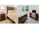 Comfortable bedroom features a wood-framed bed and dressers and neutral walls and carpet at 1126 Gate Post Ct, Powder Springs, GA 30127